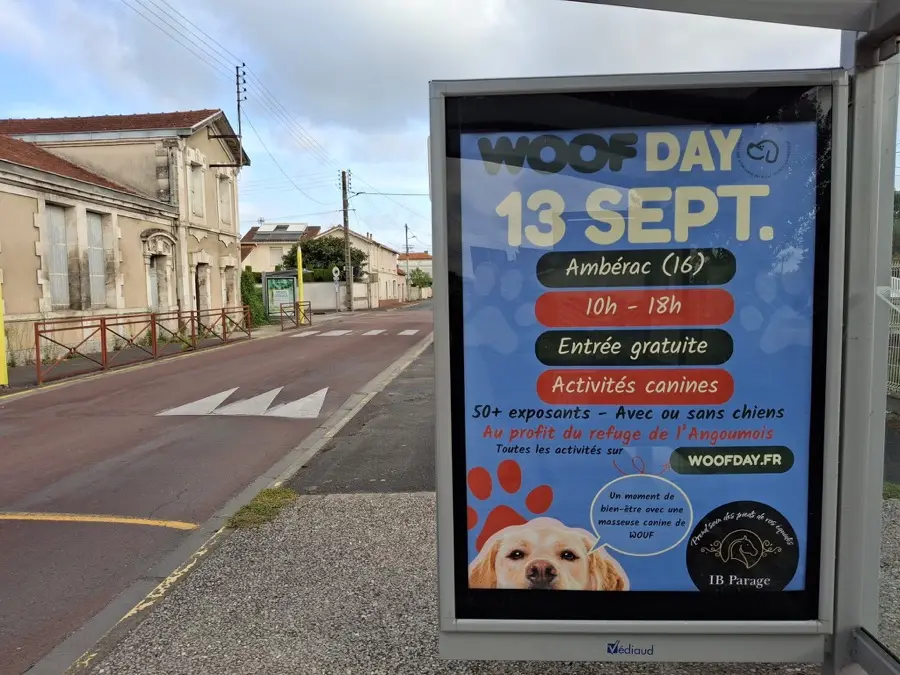 Affiche Woof Day sur un abribus, en bord de route