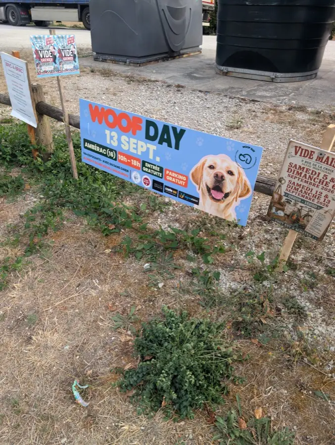 Banderole Woof Day au sol, fixée à un poteau en bord de route